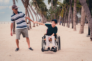 Obraz premium Father and disabled child smile face with activity outdoor on the beach, Lifestyle of disability kid travel holidays with family, Happy teenger on wheelchair.