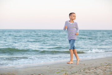 Fototapeta na wymiar Portrait of a boy at sunset by the sea
