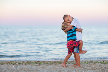 two brothers hugging by the sea