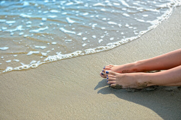 girl's feet on the sand by the sea