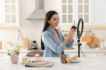 Blogger preparing for video recording in kitchen at home. Using smartphone and ring lamp