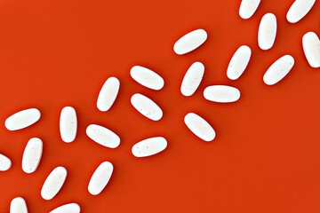close-up of magnesium pills on orange background. mental wellbeing and personal health concept - obrazy, fototapety, plakaty