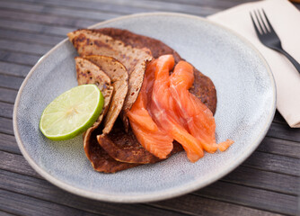 salted salmon fillet with buckwheat pancakes and lime