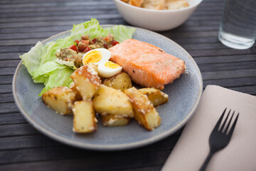 steamed salmon fillet with potato wedges, guacamole homemade and quail egg