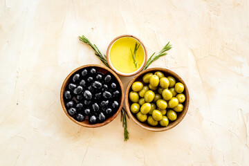 Top view of green and black olives in bowls with oil