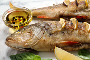 Tasty homemade roasted perches served on white board, closeup. River fish