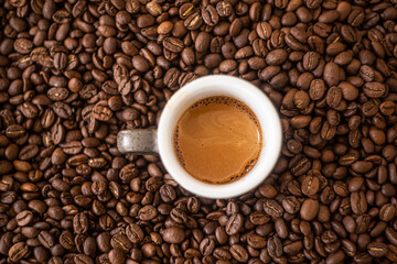 Coffee. The espresso cup is on top of the coffee beans.
