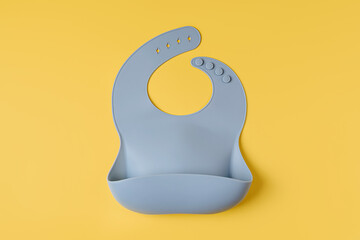 Blue silicone baby bib. First baby accessories for dinner. Top view, flat lay