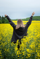 Naklejka na ściany i meble Young girl on yellow rapeseed field