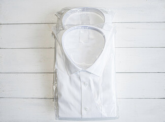 White shirt folding in the package on wooden background.
