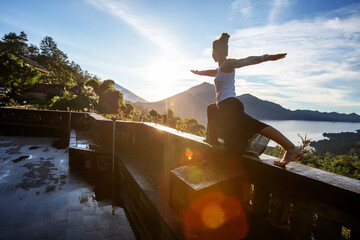 Woman doing yoga at dawn near a volcano on the island of Bali