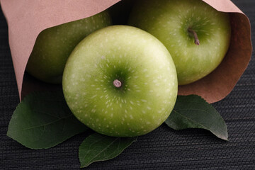 Freshly harvested green apples in a paper bag