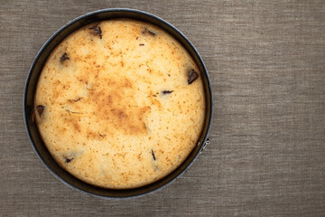 Freshly baked chocolate pie in metal mold on linen canvas