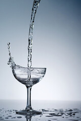 puring refreshment freshness drinking water on clean transperence glass in studio back light