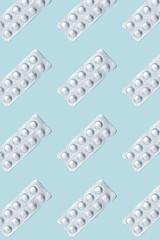 Pattern made from aluminum blister pack of tablet. Set of pills in a foil blister package on blue background. Healthcare concept.