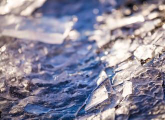 Close up of pieces of ice on frozen lake or river. Shatters of cracked ice closeup. Broken ice on the lake. Winter background.