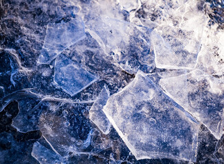 Close up of pieces of ice on frozen lake or river. Shatters of cracked ice closeup. Broken ice on the lake. Winter background.