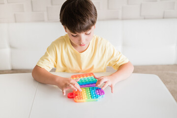 Young Little kid boy playing pop it -New Fidget Toy, Popular With Kids, Helps Them To Concentrate