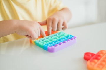 Young Little kid boy playing pop it -New Fidget Toy, Popular With Kids, Helps Them To Concentrate