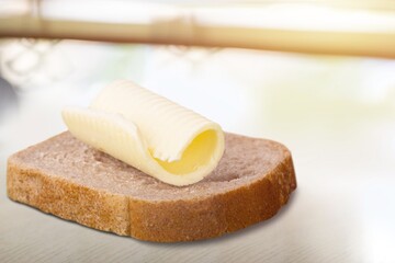 Slice of bread with butter on a kitchen desk.