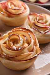 Freshly baked apple roses on plate, closeup. Beautiful dessert