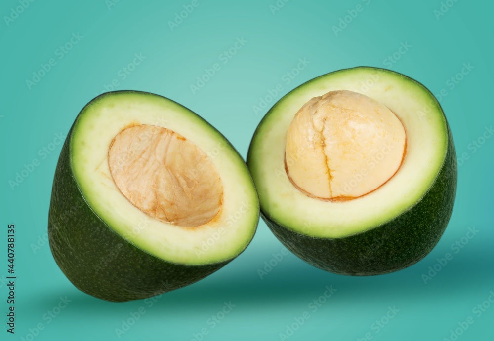 Canvas Prints two avocado cut in half with bone on a desk.