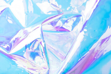 Defocused holographic background. Blurred colorful texture of wrinkled foil in blue and purple...