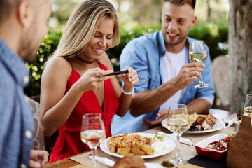 Group of Happy friends having lunch in the restaurant during a sunny summer day