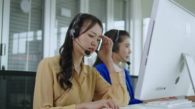 Businesswoman asia using notebook computer in office, thinking hard, wondering, stressed, worried about customer problems.telemarketing. Customer support representatives