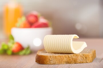 Slice of bread with butter on a kitchen desk.