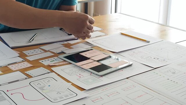 UX or UI designers collect mockup layout prototype after application project meeting.