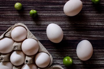 eggs with green tomatoes on wooden board
