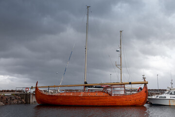 replica of a three-masted wooden Viking ship moored in the iceland sea