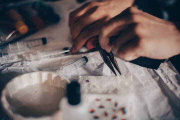 Male hands refill printer cartridge. The guy makes holes in the cartridge and pours ink through the syringe The needle makes a hole in the cartridge