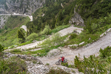 nice and active senior woman riding her electric mountainbike on the famous Tremalzo downhill from...