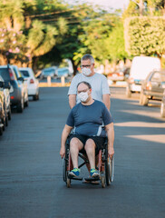Latino man using wheelchair on street.