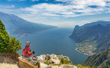 nice senior woman with elctric mountain bike resting at Punta Larici and enjoying the awesome view...
