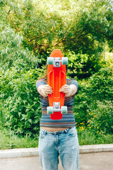 close up stylish girl carrying the penny board in the summer city park