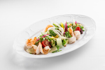 Shrimp salad with avocado and tomatoes on white plate isolated on white background