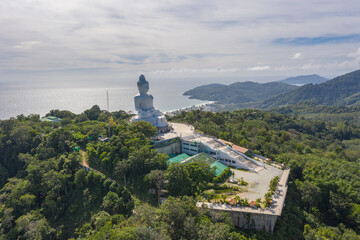 aerial photography Phuket big Buddha in sunny day.Phuket Big Buddha is one of the most important and revered landmarks on Phuket island..white cloud in blue sky, blue sea and mountain background