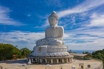aerial photography Phuket big Buddha in sunny day.Phuket Big Buddha is one of the most important and revered landmarks on Phuket island..white cloud in blue sky, blue sea and mountain background © Narong Niemhom