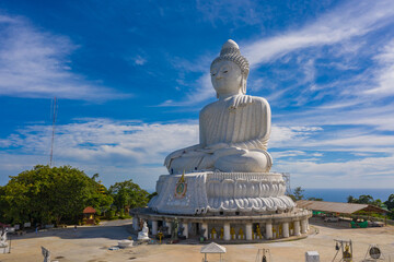 aerial photography Phuket big Buddha in sunny day.Phuket Big Buddha is one of the most important and revered landmarks on Phuket island..white cloud in blue sky, blue sea and mountain background © Narong Niemhom