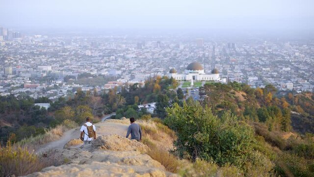Beautiful scenic view of the Griffith Observatory Park and cityscape in Los Angeles and people hiking in the mountains