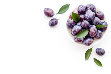 Food layout with plums in bowl with leaves. Top view