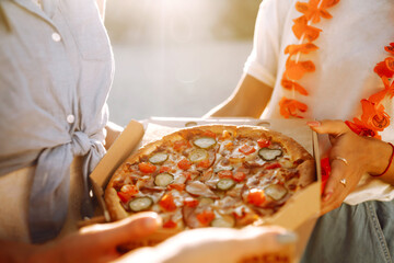 Hands taking slices of pizza close view. Group of Friends eating pizza at the beach. Fast food concept. Picnic at the beach. Summer vacation, holidays, travel, lifestyle  and people concept.