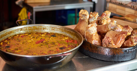 paella en paellero y codillos en olla de barro.
