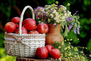 apples in a basket and a bouquet of flowers