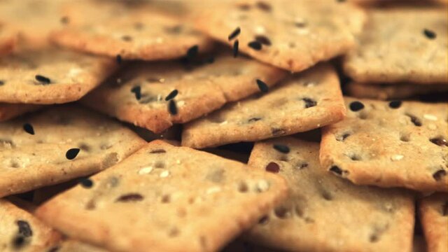 Super slow motion on the cracker falling sesame seeds. Macro background.Filmed on a high-speed camera at 1000 fps. High quality FullHD footage