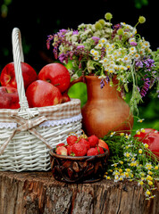 apples in a basket and a bouquet of flowers