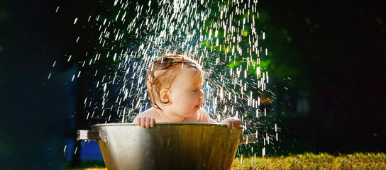 cute child in the bathtub outside in the heat of summer
